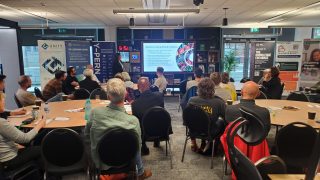 group of people sitting round tables watching a presentation