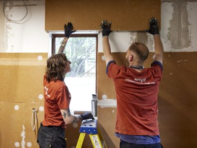 2 people putting up insulation