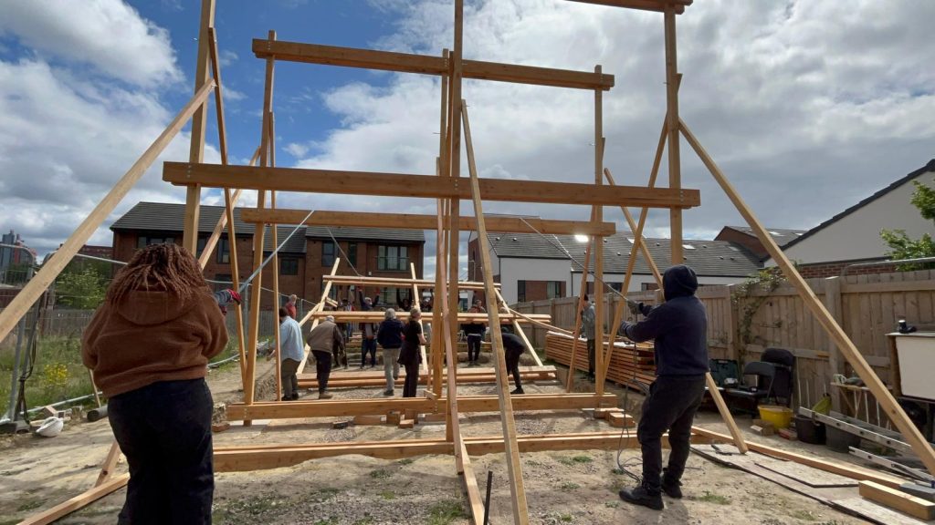people holding up wooden frame