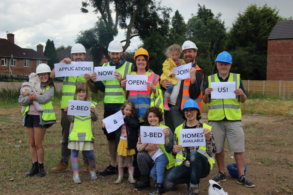 group of people holding signs about what houses they want